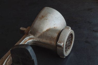 Siyah arka planda el yapımı kıyma makinesi. Çeşitli ürünleri öğütmek için el aleti. Antika mutfak aletleri..