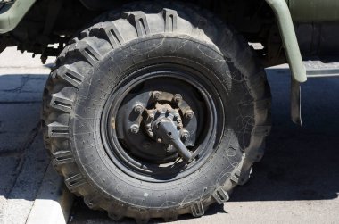 Nikolaev, Ukrayna - 20 Ağustos 2020: Sembolleri ve yazıtları olan bir Sovyet askeri kamyonunun çarkı. Büyük arazi aracının kirli tekerleği. SSCB 'nin askeri teçhizatı. Hiç kimse olmadan.