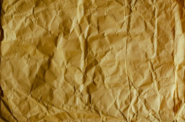 Texture of orange paper mail bag. Detail shot of crumpled paper packaging. Abstract multitasking background. Eco-friendly packaging