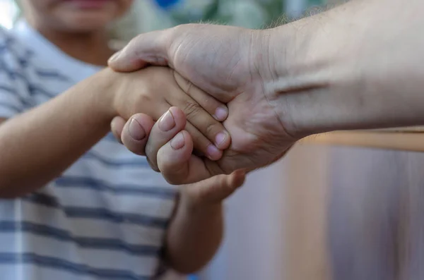 子供と大人が屋内で握手をする 幸せな時間 選択的焦点 — ストック写真