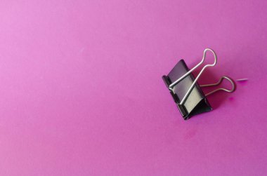 Pembe arka planda metal siyah klasörler. Kağıtlar için tek klemp. Kopyalama alanı olan asgari arkaplan.
