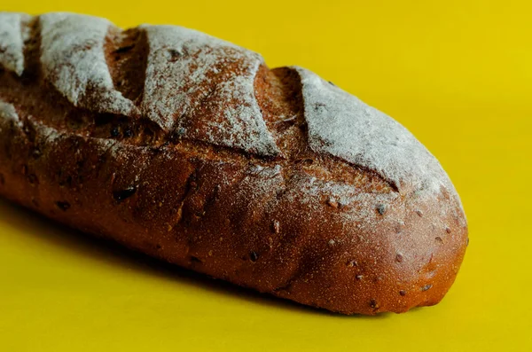 一条黄色背景的新鲜烤黑麦面包 从侧面看新鲜烘焙的自制面包撒满了面粉 复制空间 有选择的重点 — 图库照片