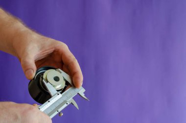 Vernier Caliper ve zamanlayıcı kemer gericiler mavi arka planda. Erkek eller yeni bir araba parçasının boyutlarını ölçer. Araba servisi. Seçici odak.