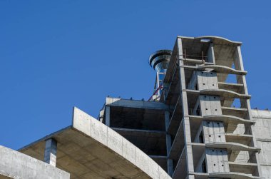 Bitmemiş bir gökdelenin beton binası. Tekrarlanan bir dizi boş kat. Soyut geometrik endüstriyel arka plan. Hiç kimse olmadan.