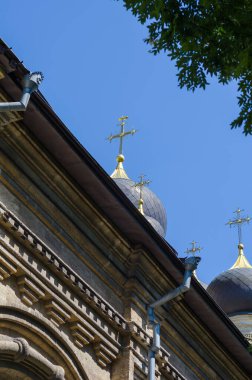 Ortodoks Kilisesi 'nin bir parçası mavi gökyüzüne karşı. Yazın gökyüzünde altın kubbeler olan eski taş kilise. Dini yerlere turist turu. Tepeden tırnağa. Seçici odak.