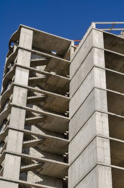 Bitmemiş bir gökdelenin beton binası. Tekrarlanan bir dizi boş kat. Soyut geometrik endüstriyel arka plan. Hiç kimse olmadan.