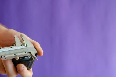 Vernier Caliper ve zamanlayıcı kemer gericiler mavi arka planda. Erkek eller yeni bir araba parçasının boyutlarını ölçer. Araba servisi. Seçici odak.