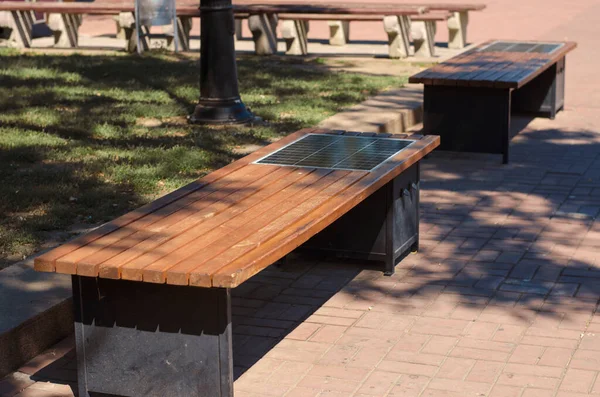 Скамейка Парке Солнечной Панелью Ряд Деревянных Скамеек Способностью Заряжать Гаджеты — стоковое фото