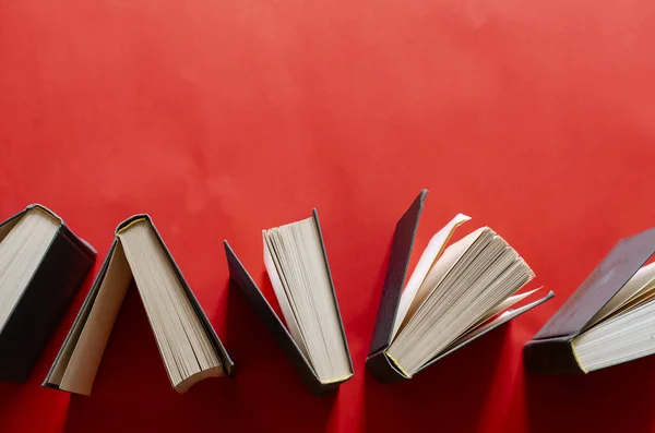 Nyílt Keménykötésű Könyvek Vörös Háttérrel Egy Ugyanilyen Stílusban Díszített Könyvcsoport — Stock Fotó