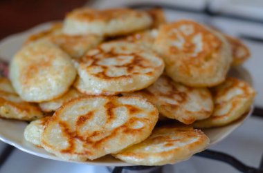 Tabakta bir porsiyon kızarmış krep. Küçük taze pişmiş krepler. Yakın plan. Ev yapımı yemek. Hiç kimse olmadan.