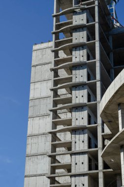 Bitmemiş bir gökdelenin beton binası. Tekrarlanan bir dizi boş kat. Soyut geometrik endüstriyel arka plan. Hiç kimse olmadan.