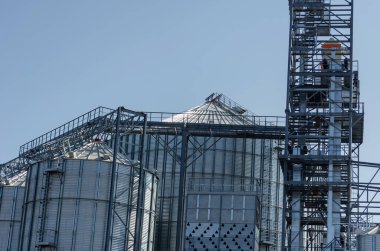 Metal bir tahıl deposunun inşaatı. Buğday, mısır, arpa ve diğer tahıl ürünleri için silindirli silolar. Sanayi, tarım sektörü. Hiç kimse olmadan