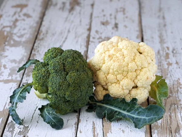 Blomkål omgiven av rustik bakgrund. Grön och vit blomkål — Stockfoto