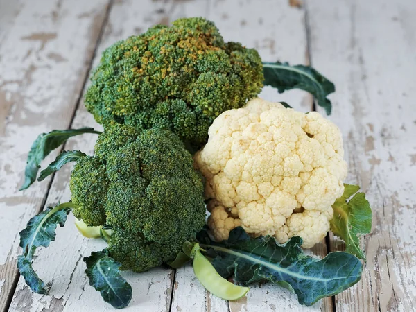 Bloemkool, omgeven door rustieke achtergrond. Groene en witte bloemkool kool. — Stockfoto