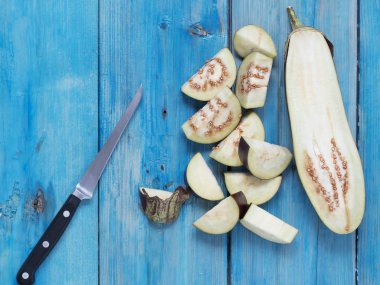 Patlıcan mavi ahşap arka plan üzerinde izole. Dilimlenmiş patlıcanlar. Yukarıdan görüntüleyin. Düz yatıyordu
