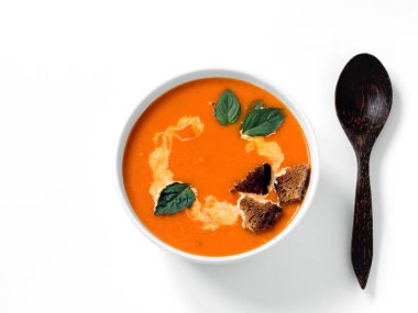 Taze domates, otlar ve zeytinyağı, fesleğen ve ekmek dilimleri, beyaz arka plan üzerinde süslenmiş ayçiçeği tohumu ve kremso ile Domates çorbası.