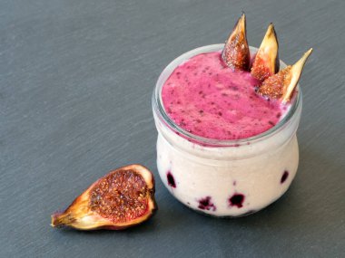 Çilek ile Smoothies: süt, kızılcık, frenk üzümü, siyah arka plan, seçici odak. Siyah taş arka plan.