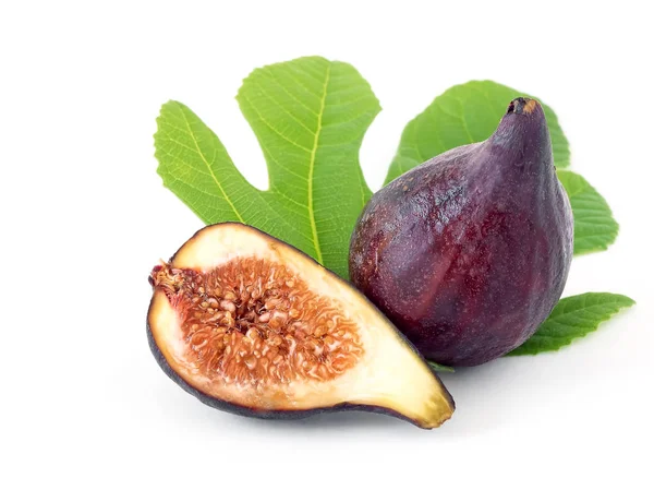 Świeże, dojrzałe figi i kawałek figów wyciąć na pół. Figi znajdujące się na liściach drzewa figowego. Izolowane na białym tle — Zdjęcie stockowe