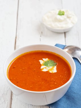 Taze domates çorbası. Mevsimlik yaz yemeği. Bir vintage beyaz arka plan üzerinde yer almaktadır. Yakında mavi kağıt havlu ve sos üzerine bir kaşık. Close.