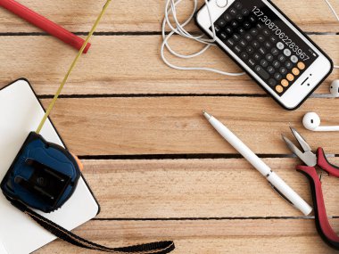 Not defterindeki finansal hedefler. Bütçe planlama kavramı. Ahşap bir masa üzerinde hesap makinesi, kahve, kalem ve akıllı telefon ile boş bir not defteri, retro tarzı.