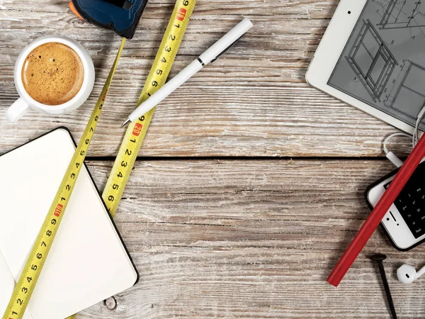 Financial goals on a notepad. Budget planning concept. On a blank notepad with calculator, coffee, pen and smart phone on a wooden table, retro style.