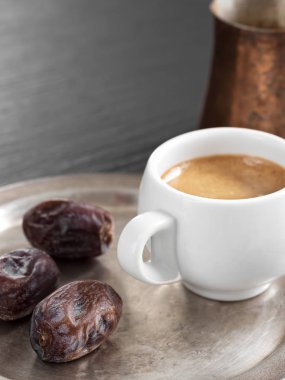 Aromatik kahve ve siyah taş masa üzerinde metal bir tabakta oryantal tarihler. Arka planda bir cezve olduğunu. Close.