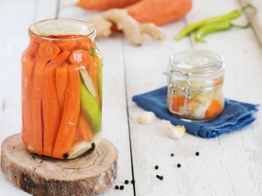 Ağaç tezgahta mayalanmış havuç, sarımsak ve zencefil. Tuzlu suyla dolu. Kış için hasat. Konserve vejetaryen yemeği. Lahana, dereotu, havuç, biber. Yakın plan. Sonbahar.