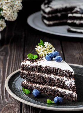 Yaban mersinli ve nane yapraklı ekşi kremalı ev yapımı vişneli pasta. Sibirya geleneksel pastası, koyu ahşap arka plan.