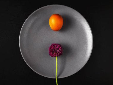 Haşlanmış yumurta ve yabani sarımsak çiçekli tabak. Siyah arka planda dümdüz yatıyordu. Oruç tutma, diyet ya da oruç tutma fikri. Sağlıklı yaşam tarzı.