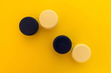 Sarı arka planda kontakt lensler için iki konteyner