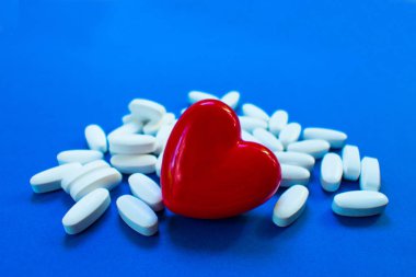 Mavi arka planda haplar ile kırmızı kalp ... Kalp hastalığı kavramı