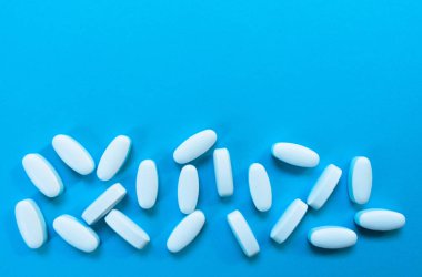 Açık mavi arka planda beyaz haplar. Boşluk Kopyala