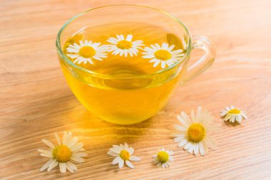 Tahta bir masada bir fincan papatya çayı. Tedavi edici bitkisel çay. Faydalı çay.