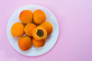 Olgun kayısı ve parlak sarı bir arka plan üzerinde yaprakları ile Plaka. Kopyalama alanı