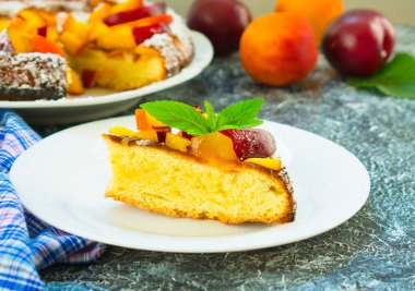 Bir tabak nane bir yaprak ile süslü şeftali ve erik ile pasta bir parça. Bir dissert hazırlama.