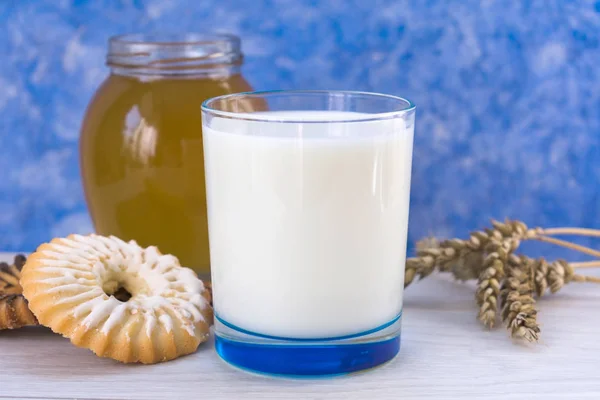 Glas Mjölk Med Kakor Och Honung Bordet Ljusblå Bakgrund — Stockfoto