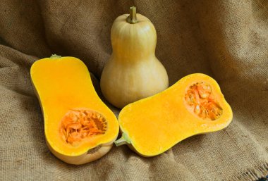 Bütün ve kahverengi bir arka plan üzerinde yarım kabak kesti. Close. Sonbahar tatili konsepti. şükran günü.