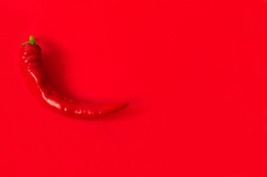  Kırmızı arka planda izole edilmiş acı biber. Kopyalama alanı.