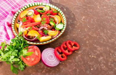  Domates salatası, biber, salatalık, soğan, otlar. Ev yapımı yemekler. Lezzetli ve sağlıklı gıda kavramı. Koyu kahverengi arka plan. Üst te. Kopyalama alanı.