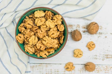 Ahşap bir arka plan üzerinde bir tabakta kabuklu ceviz. Üstte görüntü.