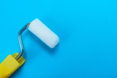 Mavi arka plan üzerinde izole edilmiş boya rulosu. Kopyalama alanı.