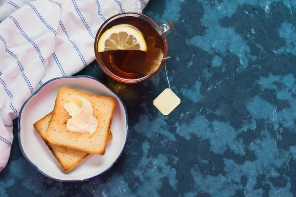 Toaster Mit Butter Und Tee Mit Zitronen Auf Blauem Hintergrund — Stockfoto