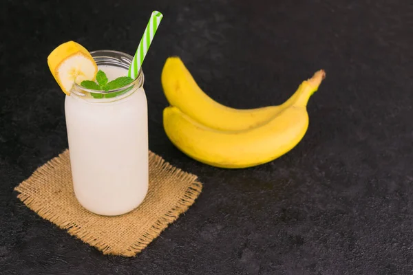 Banana and yogurt smoothies on a black background. Copy space.