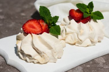 Beyaz tahta üzerinde çilekli kremalı pasta. Yakın plan.