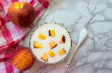 Bir tabak şeftali dilimli yoğurt. Düz yatıyordu.