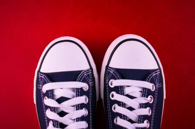 Kırmızı arka planda mavi spor ayakkabı ya da spor ayakkabı. Anlaşıldı..