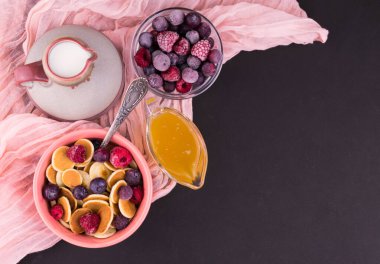 Siyah arka planda naneyle süslenmiş böğürtlen ve ballı küçük krep kahvaltısı. Krep lapası. Boşluğu kopyala.