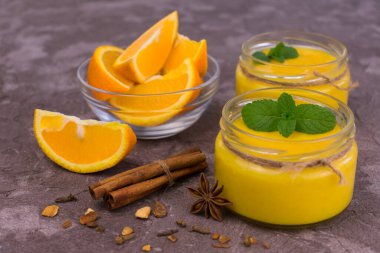 Siyah arka planda nane ve tarçınlı turuncu krema. Yakın plan..