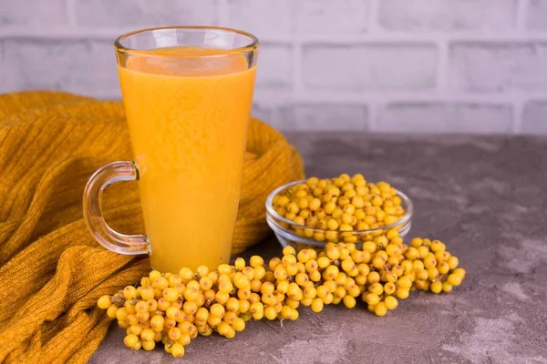 Sea buckthorn fruit drink in a high glass on a white background.