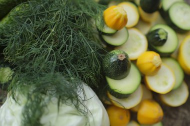 Kabak, dilimlenmiş halkalar ve diğer sebzeler, salatalık, lahana ve dereotu ile çevrili.